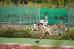 a man is running to hit a tennis ball
